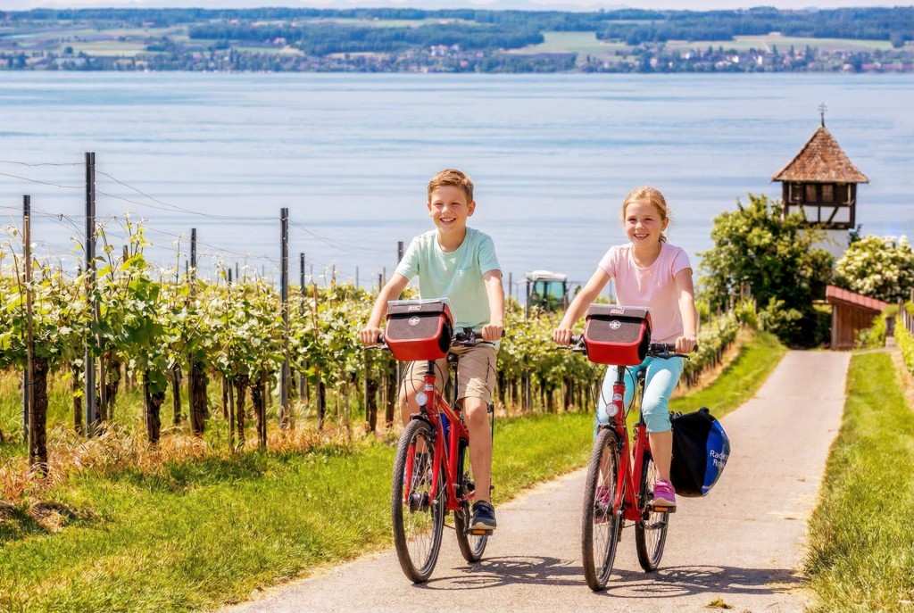 Kinder fahren Fahrrad am See